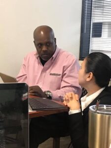 Everette Burton, a QuickBooks expert seen here with a client, said many Black business didn't qualify for federal and other loans because of poor accouting procedures. Consequently, they struggled or were forced to close. Courtesy photo.