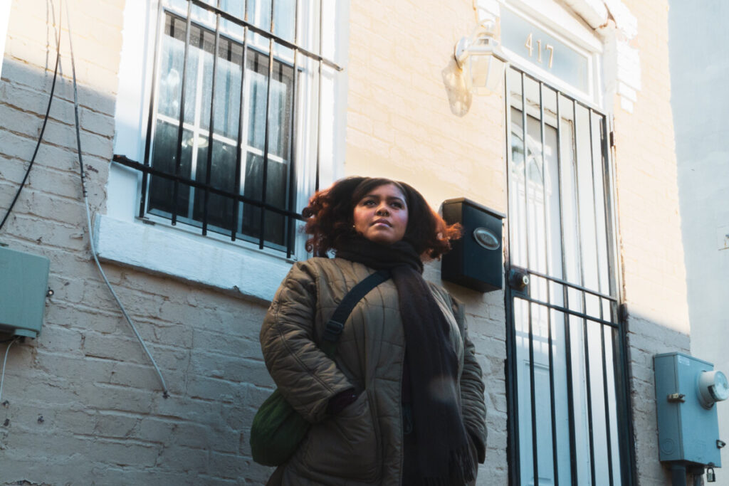 Akilah Hartgrove stands in front of her childhood home in D.C., a reminder of the neighborhood she said she hopes to remain part of. (Photo: Cole Edmonds/HUNewsService.com) 