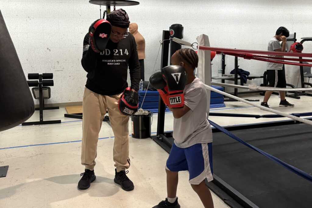 Anthony Antrum-Frank assisting his grandson at Prince George’s County Police Athletic League Connect Boxing practice. (Photo: Taylor Swinton/HUNewsService.com)
