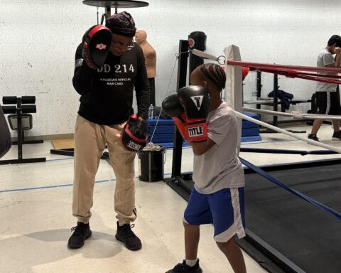 Anthony Antrum-Frank assisting his grandson at Prince George’s County Police Athletic League Connect Boxing practice. (Photo: Taylor Swinton/HUNewsService.com)