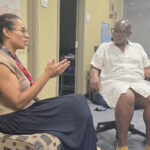Dr. Anita Plummer speaking with colleagues at the Louis Stoke Health Sciences Library (by Israel Johnson)