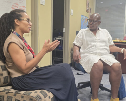 Dr. Anita Plummer speaking with colleagues at the Louis Stoke Health Sciences Library (by Israel Johnson)