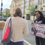 Rhonda Hamilton, the independent candidate for D.C. mayor, talks with a mother and daughter in Ward 5 near Catholic University of America about sports and athletics — the girl enjoys the breaststroke when she swims. (Photo: Myla S. Roundy/HU News Service)