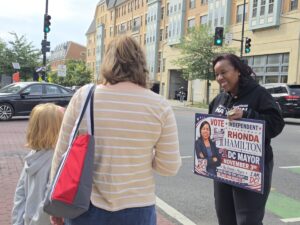 Rhonda Hamilton, the independent candidate for D.C. mayor, talks with a mother and daughter in Ward 5 near Catholic University of America about sports and athletics — the girl enjoys the breaststroke when she swims. (Photo: Myla S. Roundy/HU News Service)