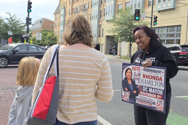 Rhonda Hamilton, the independent candidate for D.C. mayor, talks with a mother and daughter in Ward 5 near Catholic University of America about sports and athletics — the girl enjoys the breaststroke when she swims. (Photo: Myla S. Roundy/HU News Service)