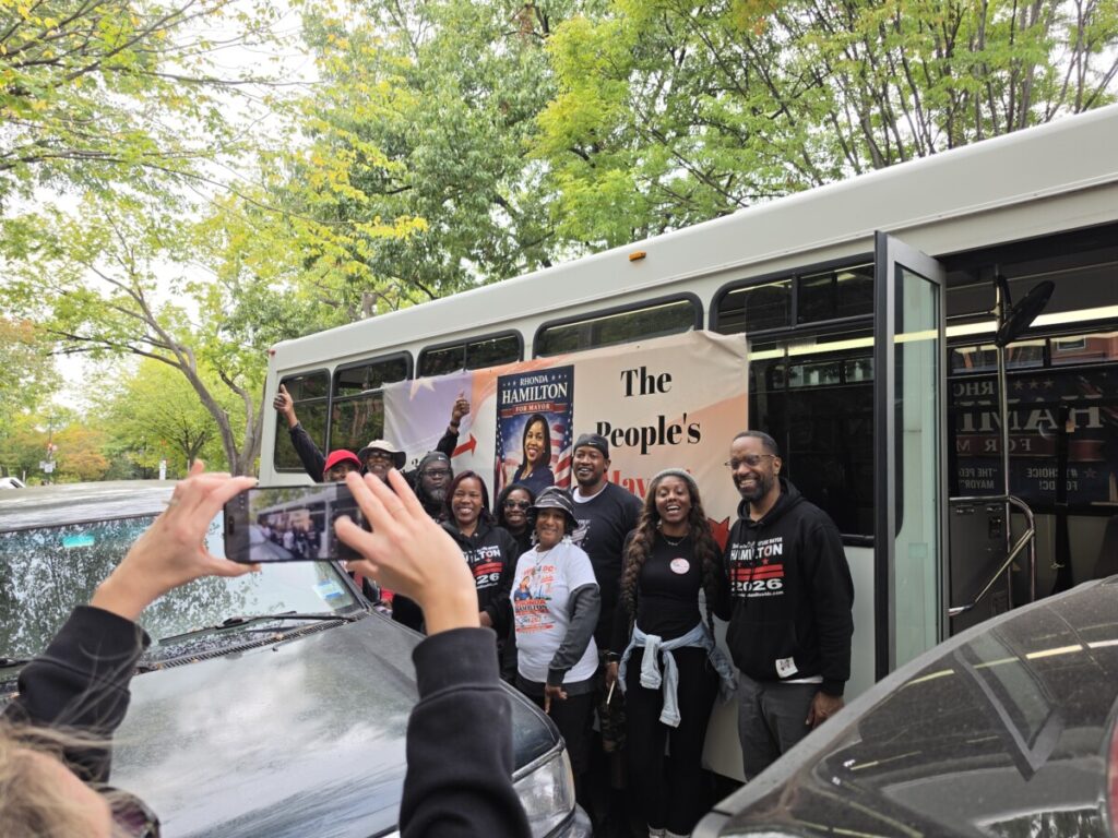 Rhonda Hamilton, the independent candidate for D.C. mayor, poses for a photo with volunteers outside of their campaign bus on Saturday, Oct. 10. Hamilton said the campaign team has about 24 members, all of whom are unpaid volunteers. (Photo: Myla S. Roundy/HU News Service)